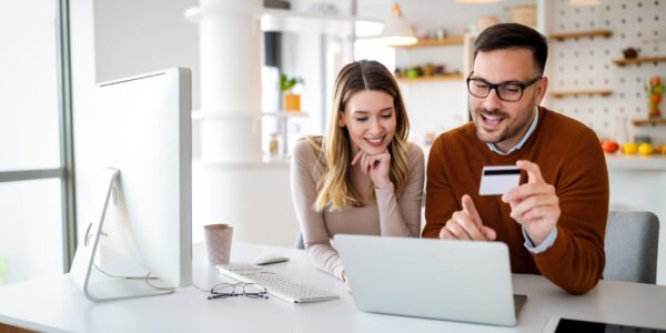 Portrait of a cheerful couple in love shopping online. Technology, e-commerce, banking concept